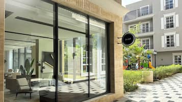 A modern building with large glass windows, a sign reading "Kease", and a small outdoor area with a playground.