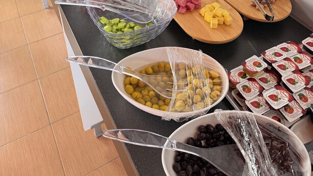 Un tavolo per buffet con diversi cibi, tra cui frutta, verdura e snack.