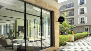A modern building with large glass windows, a sign reading "Kease", and a small outdoor area with a playground. - Hittin B-3 Latest Development  AX58 (Riyadh)