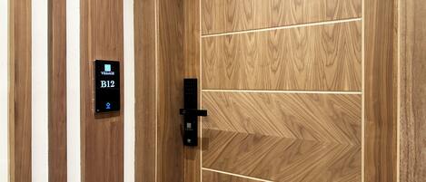 A wooden door with a digital lock and a keycard reader displaying 'VITEAGE B12'.