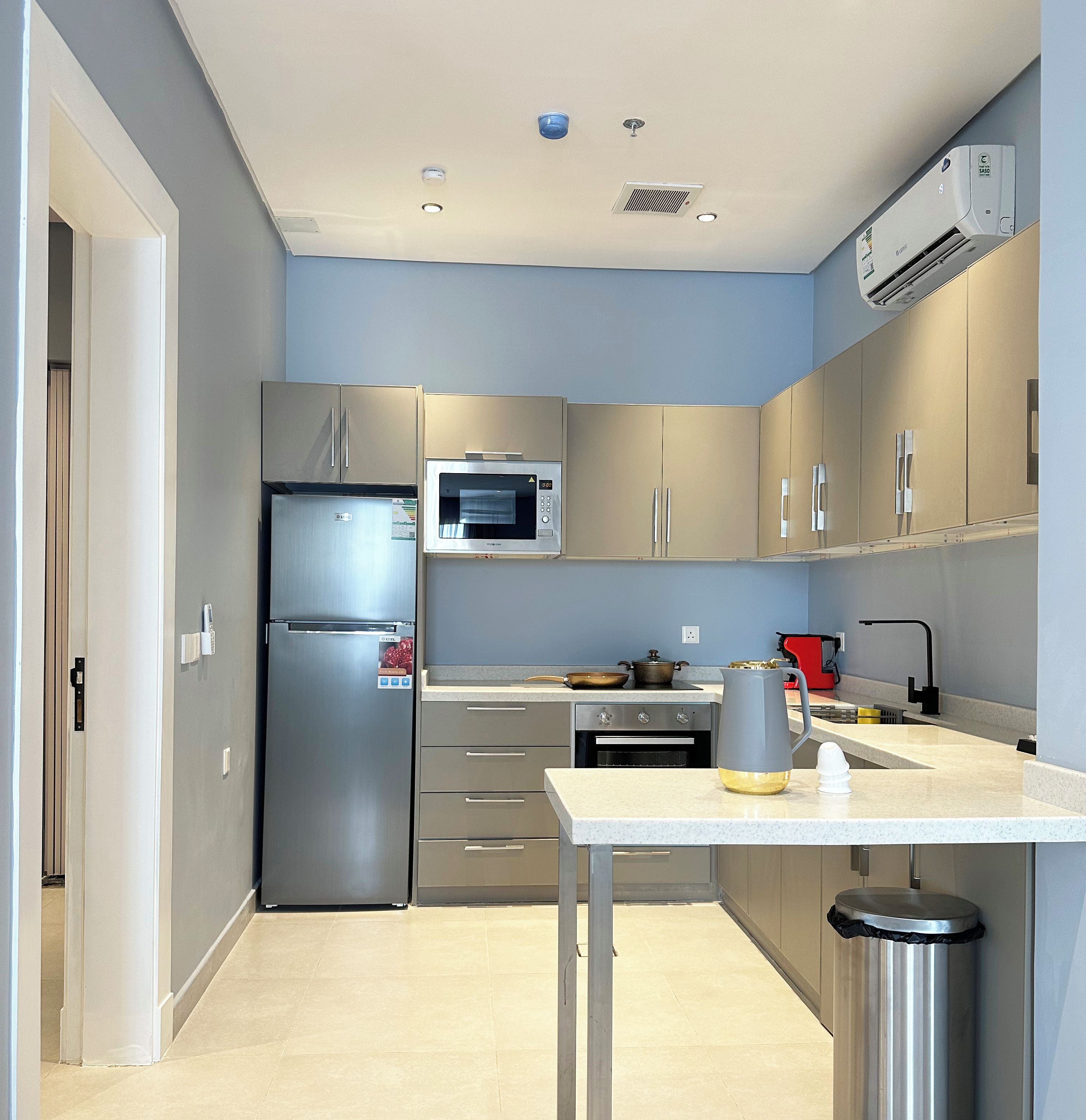 A modern kitchen with stainless steel appliances, a microwave, and a sink.