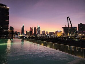 A city skyline at dusk with a river in the foreground and a bridge in the middle. - Kotrip Metropole Paradise Vacation (Ho Chi Minh City)