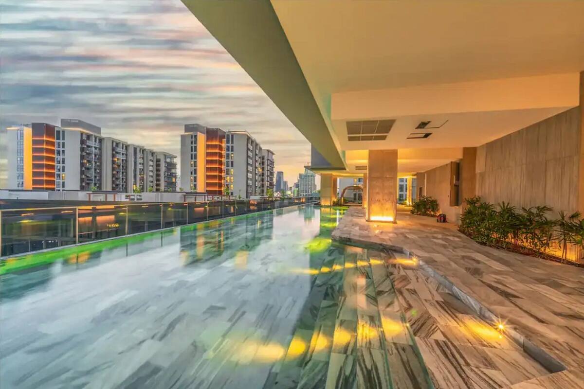 Een modern gebouw met een glazen zwembad, uitzicht op wolkenkrabbers en een goed verlicht interieur.