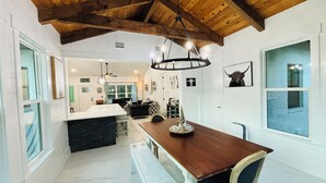A spacious kitchen with a wooden ceiling, a central island, and a dining area with a bench. - Private 30A Retreat-Large Yard-Hot Tub-2 KING Suites-Fire Pit-Boat & RV parking. (Santa Rosa Beach)