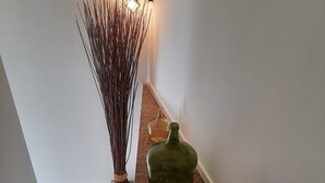 A staircase with a woven carpet, a green vase, and a tall vase on the floor. - Les Myrtes Studio Style Atelier (Cuers)