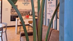 A modern kitchen with white cabinets, a central island, and a hanging light fixture. - Wonderful cottage with swimming pool 100 mt from the sea 🌊 (Trabia)