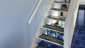 Un escalier avec des rampes blanches et des marches recouvertes de carreaux bleus.