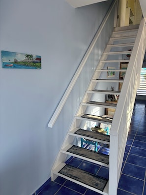 A staircase with white railings and blue-tiled steps.