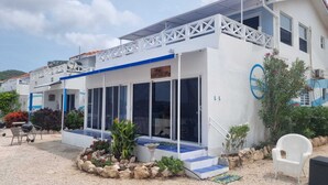Un bâtiment blanc avec un toit bleu, de grandes fenêtres et une enseigne sur laquelle on peut lire « Sandy Bottoms ».