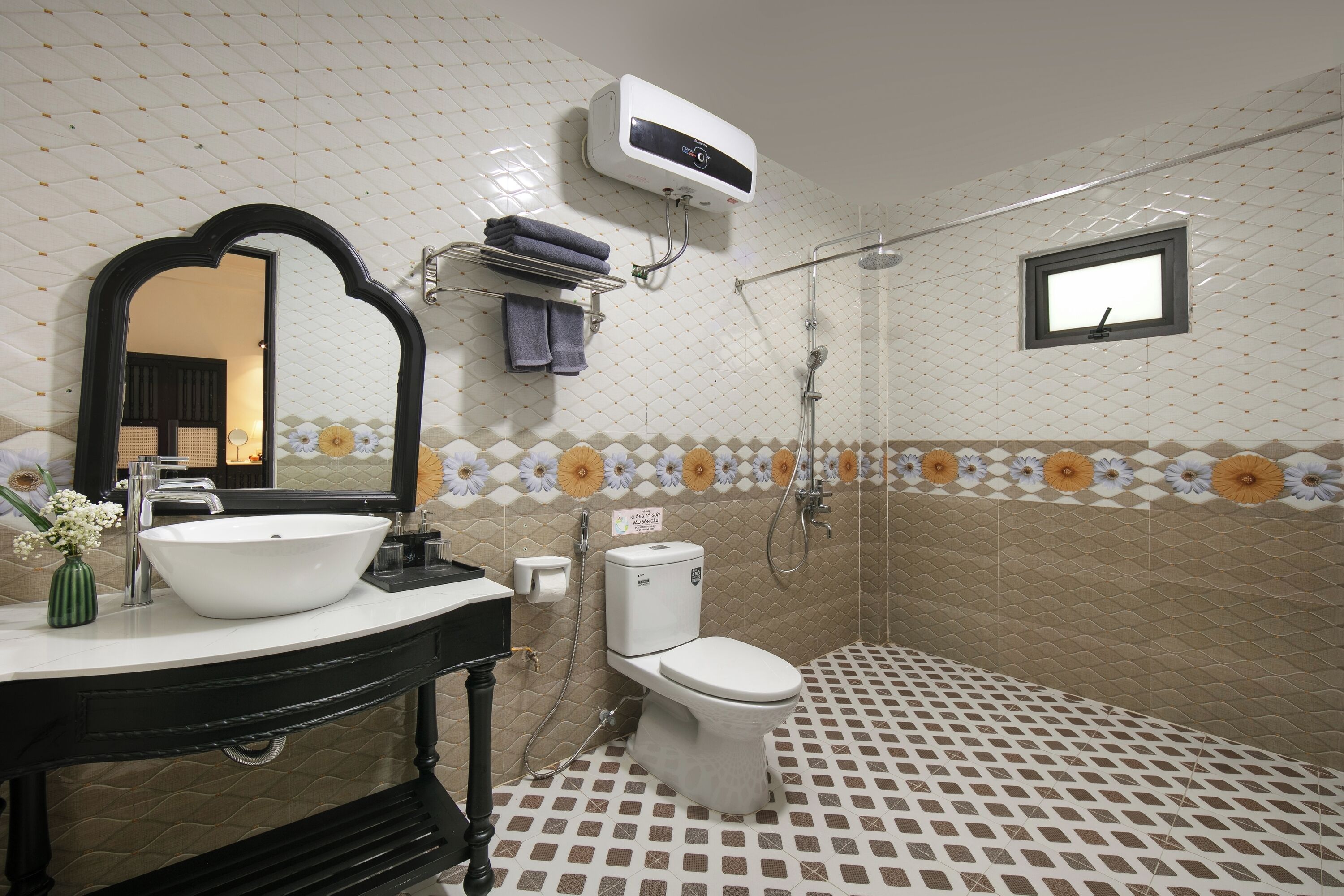 A bathroom with a white sink, a toilet, a shower, and a mirror.