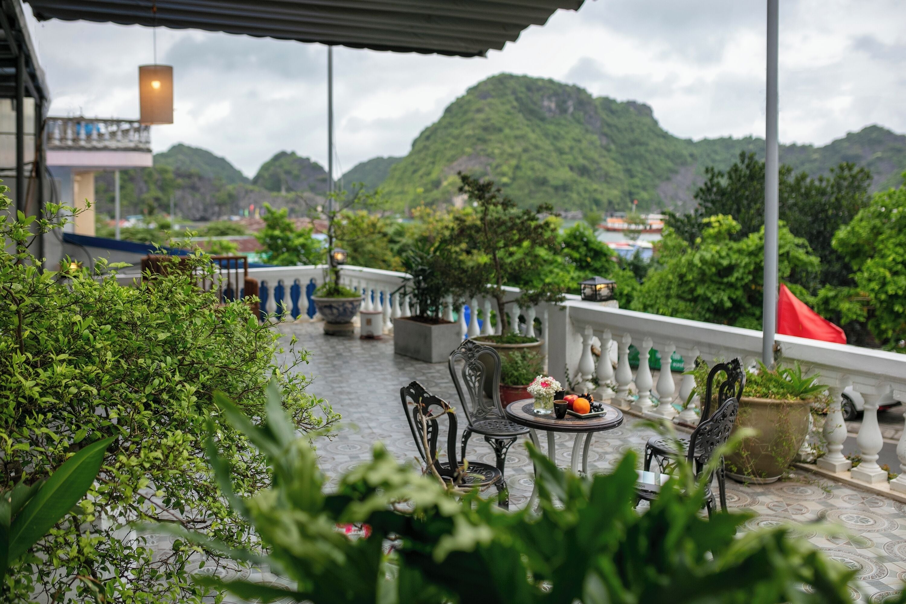 A terrace with outdoor seating, potted plants, and a view of green hills.
