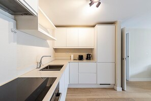 Una cocina moderna con un lavamanos, estufa y armarios.