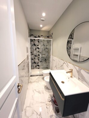 Een douche, een haardroger, een bidet, handdoeken