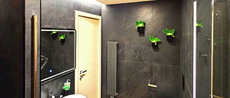 A modern bathroom with two sinks, a toilet, and a shower.