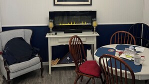 Ein Essbereich mit Tisch, Stühlen, einem Fernseher und einem gerahmten Bild an der Wand.