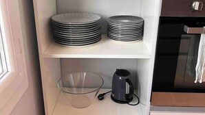 A kitchen with white shelves holding bowls, plates, and a kettle. - Beautiful modern 7th floor apartment with panoramic views  (Chambéry)