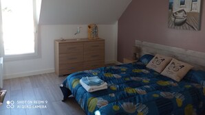 A bedroom with a bed, dresser, and a painting on the wall.