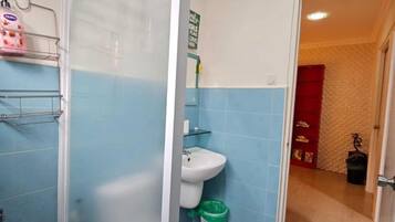 Un baño con cabina de ducha, lavabo e inodoro.