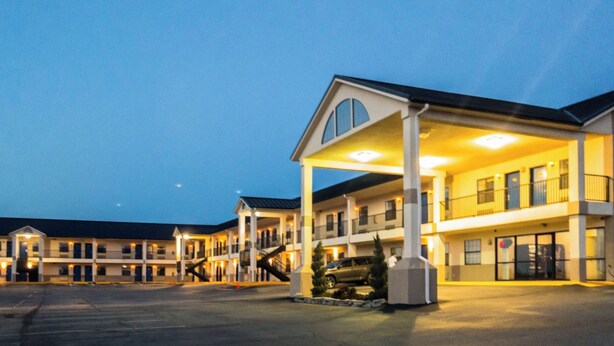 A motel with multiple buildings, a covered parking area, and a staircase leading to the upper floors. - Hiway Inn Express Of Coalgate (Coalgate)