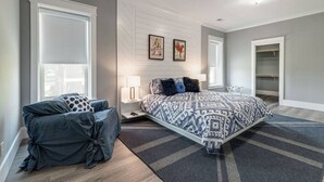 A bedroom with a large bed, a bedside table with a lamp, a wardrobe, and a window with blinds. - Downtown`s BEST LOFT ON THE SQUARE  `THE FIDDLE`!!! (Smithville)