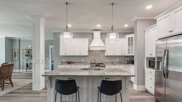 A modern kitchen with white cabinetry, a central island with bar stools, stainless steel appliances, and pendant lighting. - Downtown`s BEST LOFT ON THE SQUARE  `THE FIDDLE`!!! (Smithville)