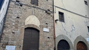 Un bâtiment historique en pierre, doté d’une haute tour, de portes en arc de cercle et d’une enseigne indiquant une clinique vétérinaire.