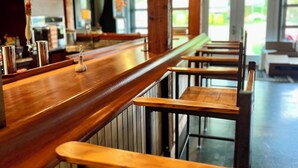 Una zona de bar con taburetes de madera y una barra.