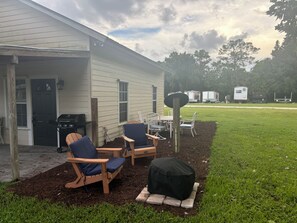 A house with a covered patio area featuring outdoor furniture and a grill. - The Goodlife cottage#2 quiet and relaxing (Palm city)