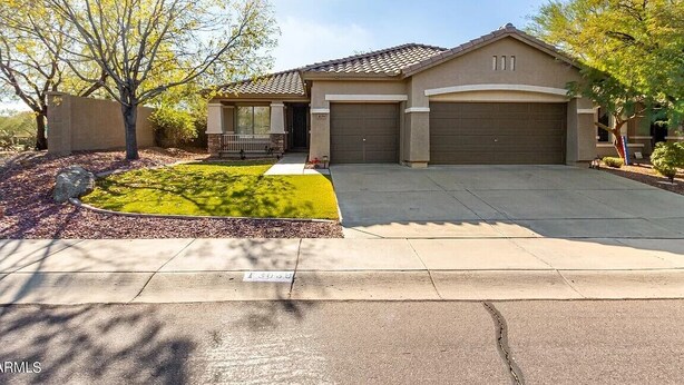 A single-story house with a garage, a covered porch, and a well-maintained lawn. - Anthem Family getaway (Anthem)