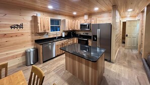 Una cucina moderna con mobili in legno, elettrodomestici in acciaio inossidabile e un'isola centrale.