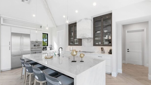 A modern kitchen with a large island, stainless steel appliances, and a view of the outdoors. - Bella Fratelli Marco Island 🏝️
With Electric Lift Pier (Marco Island)