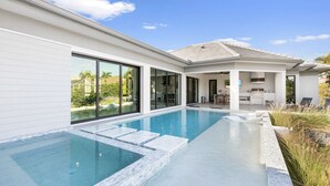 A modern house with a swimming pool, large windows, and a patio area. - Bella Fratelli Marco Island 🏝️
With Electric Lift Pier (Marco Island)