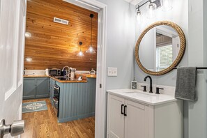 Een keuken met houten plafond, een spoelbak en een spiegel.