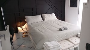 Una camera da letto moderna con un letto, comodini e una testiera con motivi geometrici.