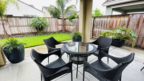 A patio with a round glass table and six wicker chairs. - Lovely Home in Lodi (Lodi)