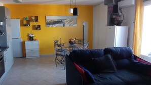 A compact living space with a dining area, kitchen, and a sofa. - Proche Mer, Appartement Classé 2 Dans Petite Résidence (Santa-Lucia-di-Moriani)