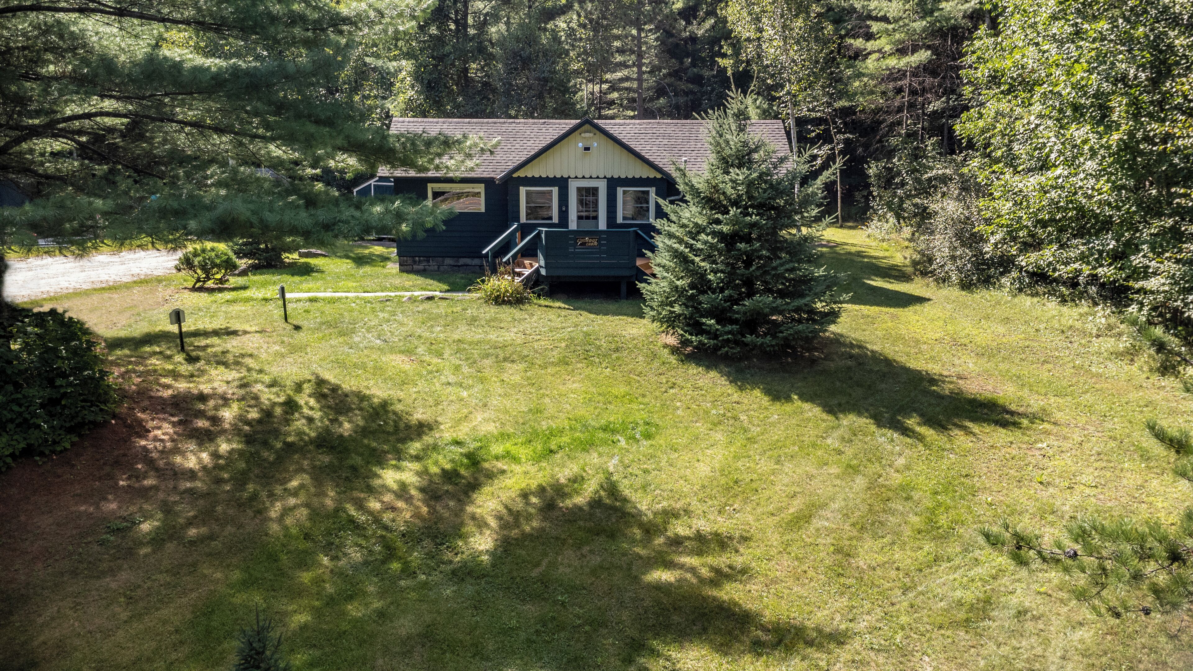 A house with a front porch, surrounded by a well-maintained lawn and trees.