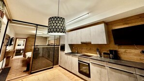 A modern kitchen with a built-in oven, a large window, and a pendant light. - Apart Darre (Serfaus)