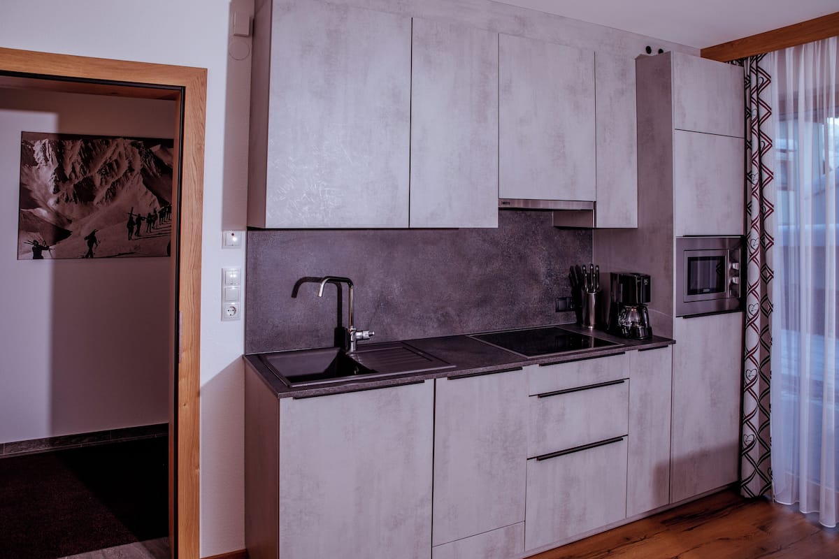 Studiosvit Comfort - 1 kingsize-sÀng med bÀddsoffa - utsikt mot bergen | Eget pentry | Stort kylskÄp, mikrovÄgsugn, spishÀll och diskmaskin