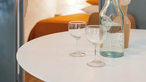 A round white table with a glass bottle and two wine glasses on it. - T2 Tout Confort - Central- Bord de mer 100m - Clim (La Ciotat)