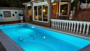 Ein Schwimmbecken mit gefliestem Deck und weißem Geländer.