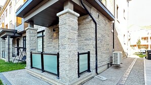 A modern building with a stone facade, large windows, and a covered outdoor area. - Your Private Space - Nothing Shared (Brampton)