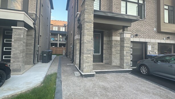 A modern residential building with a stone facade, large windows, and a driveway. - Your Private Space - Nothing Shared (Brampton)