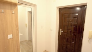 Un pasillo con una puerta de madera y una puerta de madera oscura.