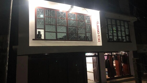 A building with a large illuminated window and a sign that reads "BMRM". - Hotel D4 Red Mud (Thuli Bheri)