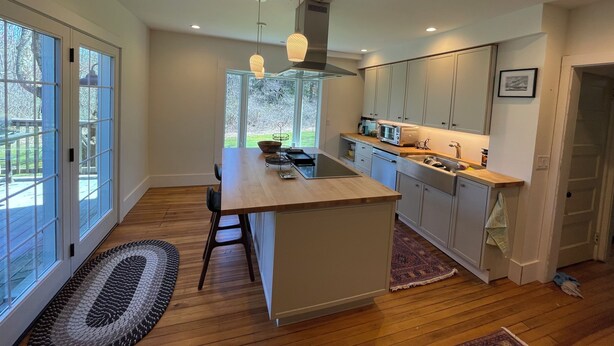 A modern kitchen with a central island, wooden flooring, and large windows. - Relax or be active! The choice is yours in this pet-friendly family home.  (Norfolk)