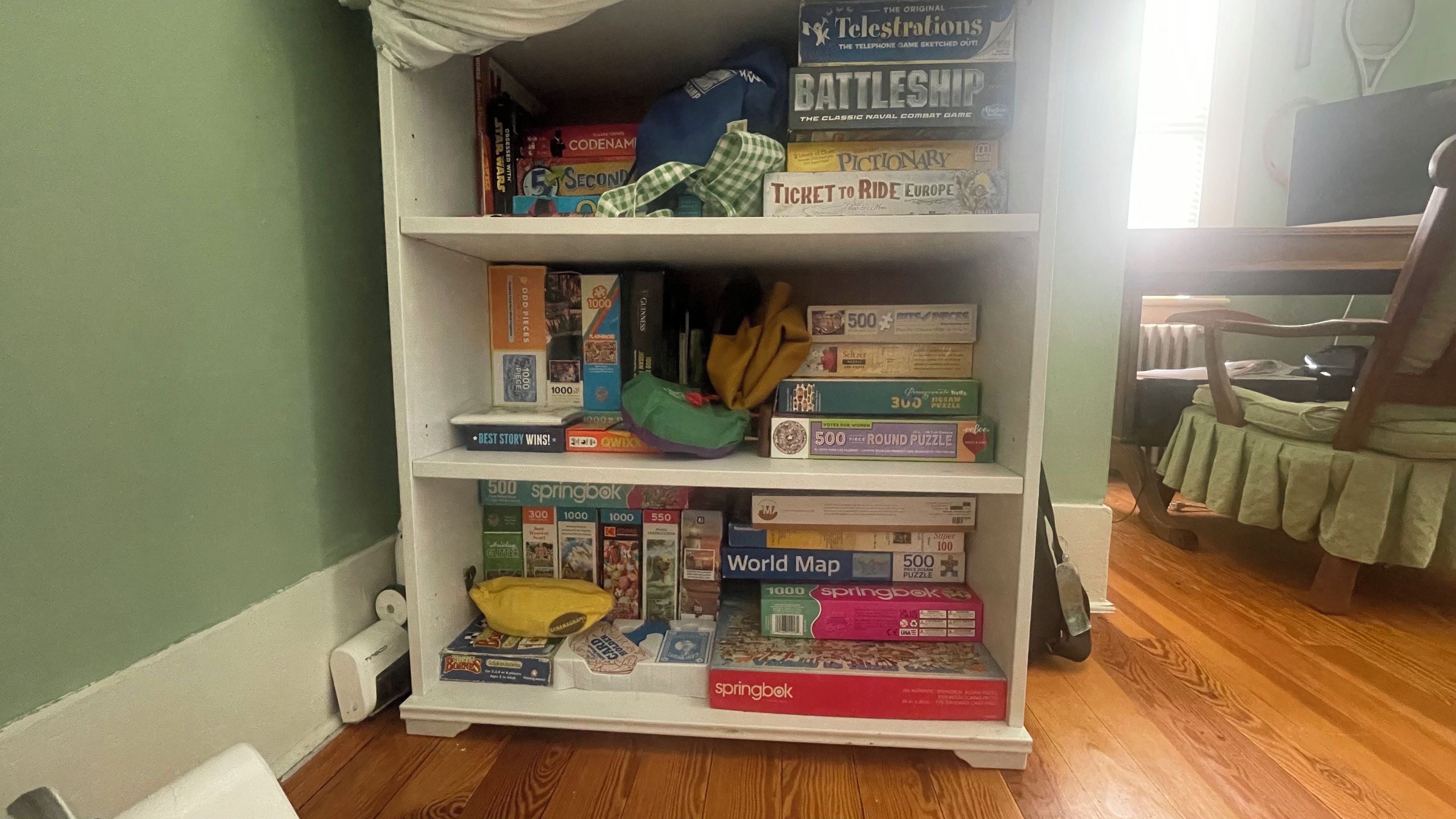 Ein Bücherregal mit verschiedenen Gesellschaftsspielen und Puzzles.