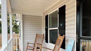 Eine Veranda mit zwei Schaukelstühlen und einem 'WELCOME'-Schild.