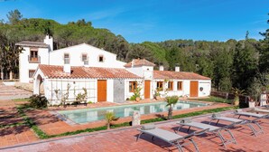 A white building with a swimming pool and lounge chairs. - Masia Can Casas (Sant Iscle de Vallalta)
