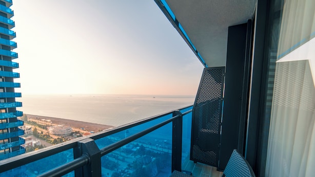 A balcony with a view of the ocean and cityscape. - black sea royal panorama (Batumi)
